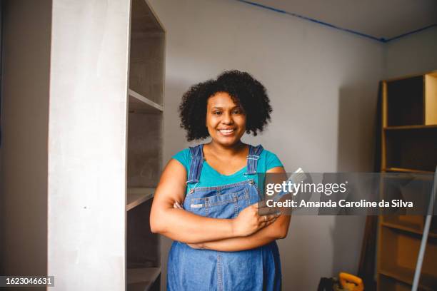 brazilian black woman painting a wooden cabinet in the middle of a renovation - reforma stock pictures, royalty-free photos & images