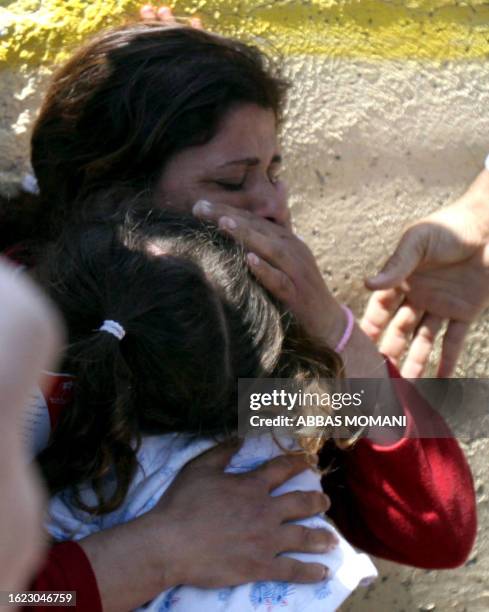 Palestinian woman suffering from the effects of tear gas holds her young daughter after a tear gas canister was lobbed by the Israeli army during a...