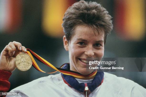 German athlete Grit Breuer holds a gold medal won in a women's sprint event at the 1996 German Indoor Athletics Championships, held at the...