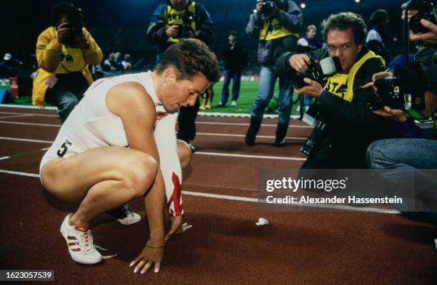 German athlete Grit Breuer sitting on her haunches as photographers gather before her at the 1995 Internationales Stadionfest athletics meeting, held...