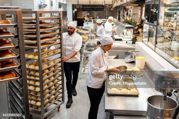 group of employees working at a bakery baking bread - fazer pão imagens e fotografias de stock