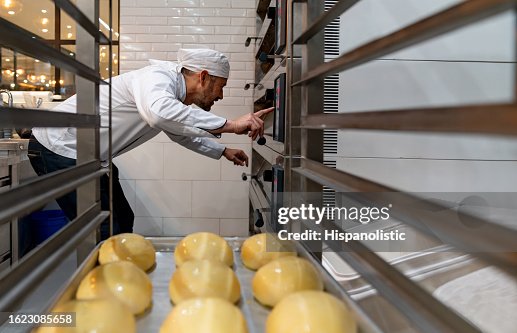 Baker preparing the oven to bake bread at the bakery