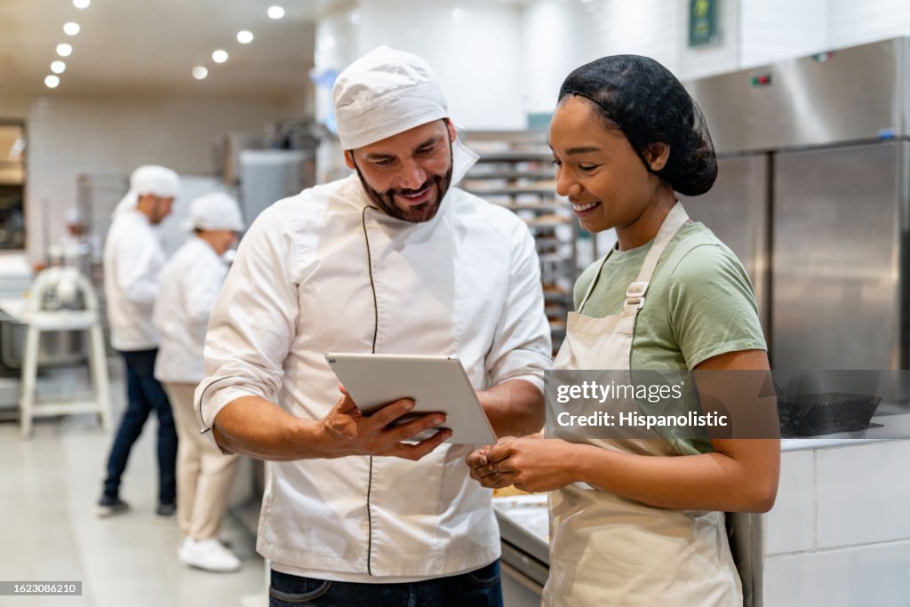 Bäcker schult einen neuen Mitarbeiter in der Bäckerei
