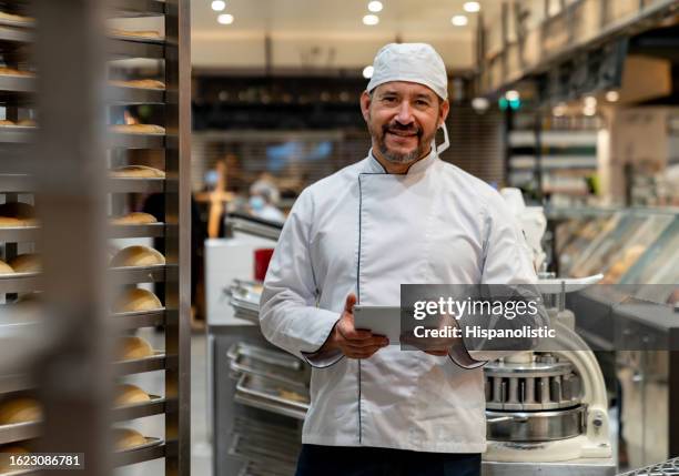 feliz propietario de un negocio que administra una panadería y usa una tableta digital - cooking pan fotografías e imágenes de stock