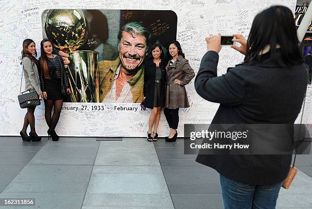 Fans pose for a picture in front of the display of Dr. Jerry Buss after his memorial service outside the Nokia Theatre L.A. Live on February 21, 2013...