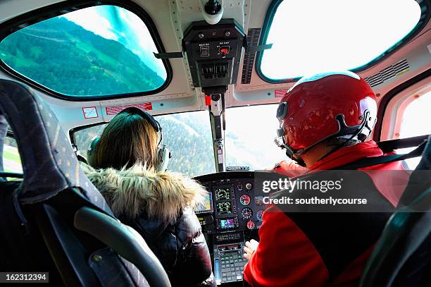 pilot and female passenger in cockpit of a modern helicopter - inside helicopter stock pictures, royalty-free photos & images