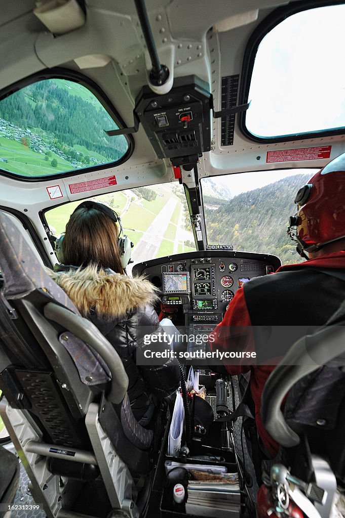 Pilot und weibliche Passagiere im Cockpit in einem modernen Hubschrauber