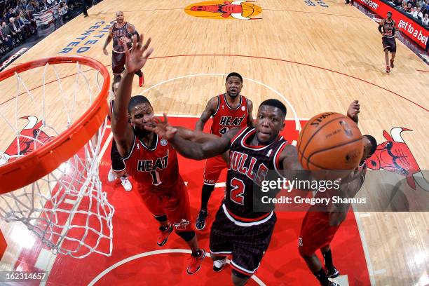 Nate Robinson of the Chicago Bulls attempts a layup against Chris Bosh of the Miami Heat on February 21, 2013 at the United Center in Chicago,...