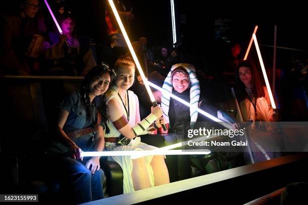 Fans in cosplay pose with lightsabers in the theater during the Ahsoka Fan Event at AMC Empire 25 on August 17, 2023 in New York City.