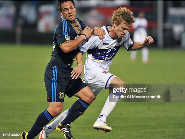 Midfielder Danny Cruz of the Philadelphia Union runs upfield with defender Brian Fekete of Orlando City February 9, 2013 in the first round of the...
