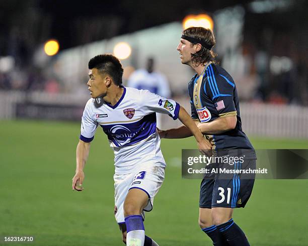 Forward Long Tan of Orlando City runs upfield against defender Jeff Parke of the Philadelphia Union February 9, 2013 in the first round of the Disney...