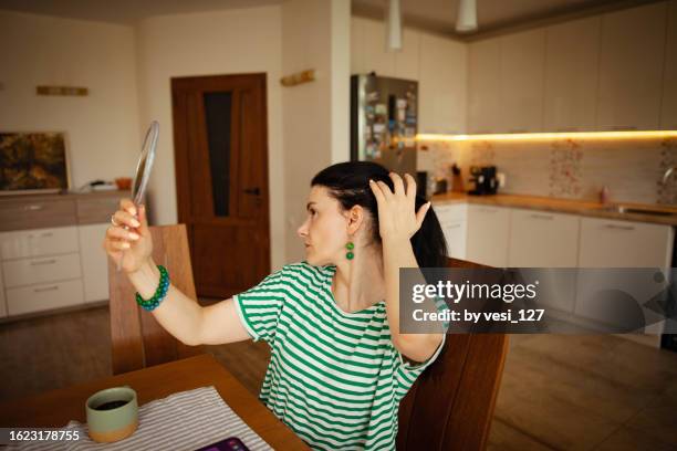 a woman, 40-45 years, doing a scalp check - 40 44 years woman caucasian stockfoto's en -beelden