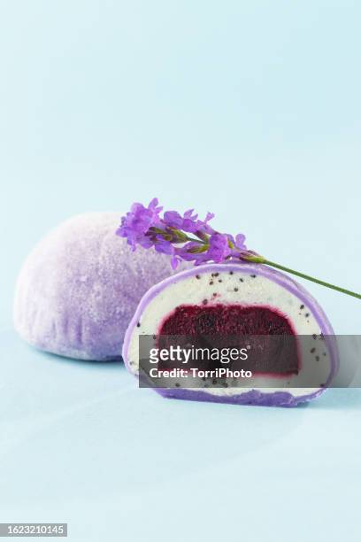 traditional daifuku mochi with lavander flavor and bluberry filling on blue background. cut in half dessert - bluberry imagens e fotografias de stock