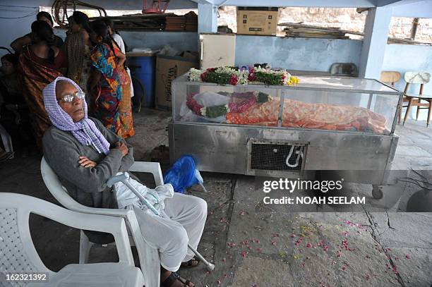 Sukka Kondaiah 80 years old, sits beside the body of her son Sukka Venkateshwarlu, lying in a coffin after dying in a bomb blast, at their residence...