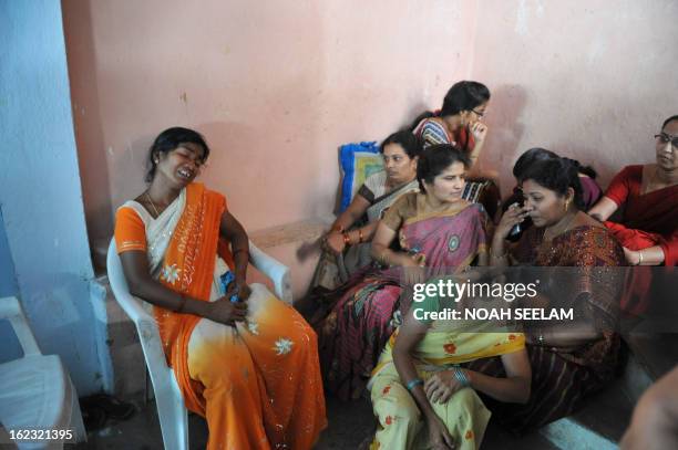 Sukka Sujatha , the wife of Sukka Venkateshwarlu, reacts as his body lies in a coffin after dying in a bomb blast, in Hyderabad on February 22, 2013....