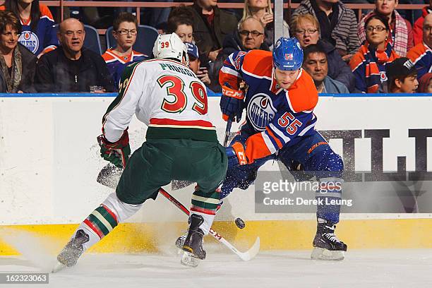Ben Eager of the Edmonton Oilers skates with the puck against Nate Prosser of the Minnesota Wild during an NHL game at Rexall Place on February 21,...