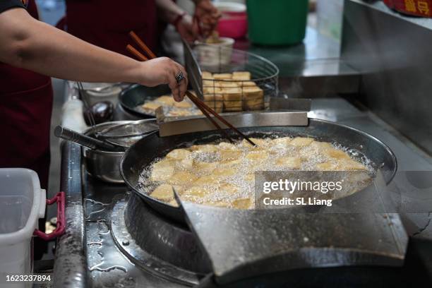 stinky tofu in frying pan. - freír mediante inmersión total en aceite caliente fotografías e imágenes de stock