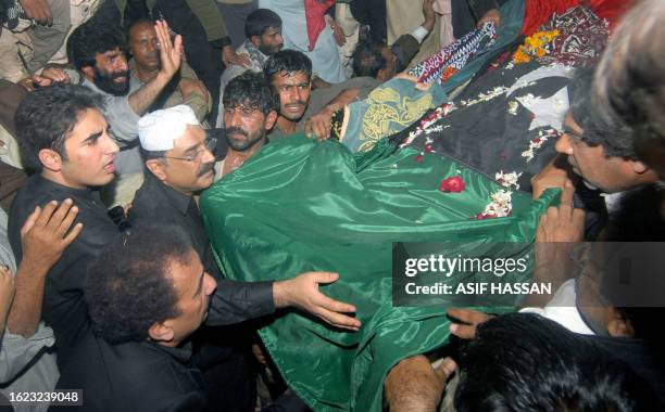 Asif Ali Zardari husband of former Pakistani premier Benazir Bhutto and his son Bilawal lower her coffin into the grave after her funeral prayers at...