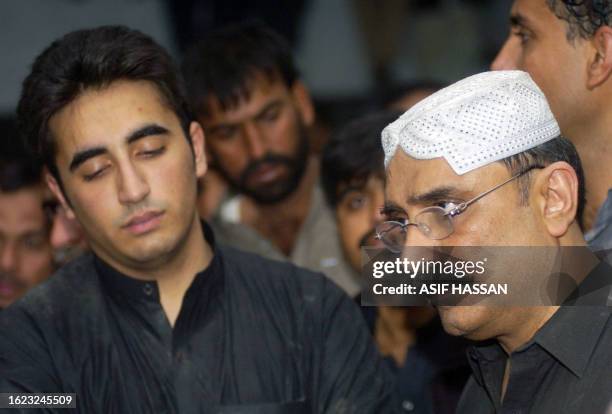 Asif Ali Zardari husband of former Pakistani premier Benazir Bhutto and his son Bilawal stand infront of her grave following her burial at Ghari...