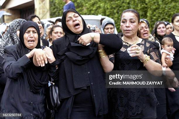 Lebanese women cry in mourning during a funeral procession for Lebanese army officer Ali Nassar in the village of Kfar Hata south of Beirut, 02...