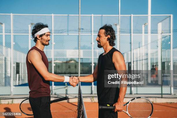 two tennis players shaking hands in the middle of the court - finals game two stock pictures, royalty-free photos & images