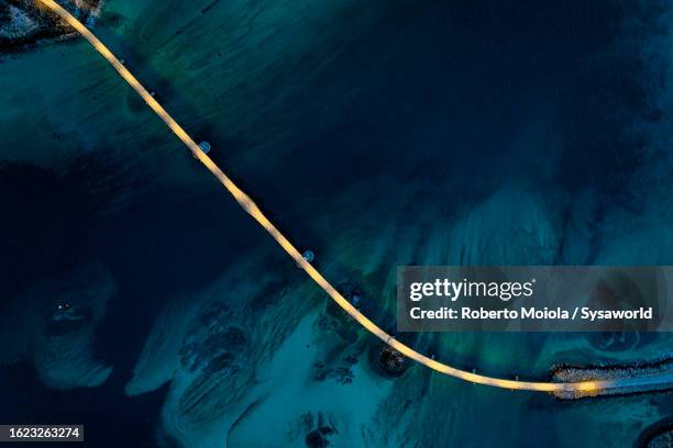 illuminated bridge in the cold arctic sea at dusk - vogelperspektive stock-fotos und bilder