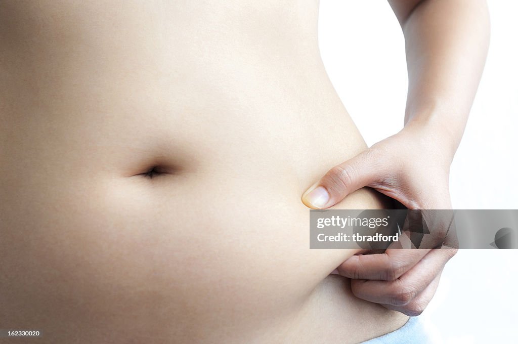 Asian Woman Pinching Her Belly Fat With Left Hand