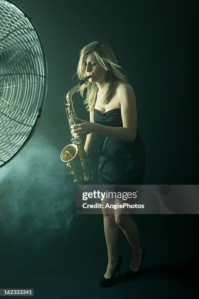 belle femme jouant au saxophone - machine à faire du vent photos et images de collection