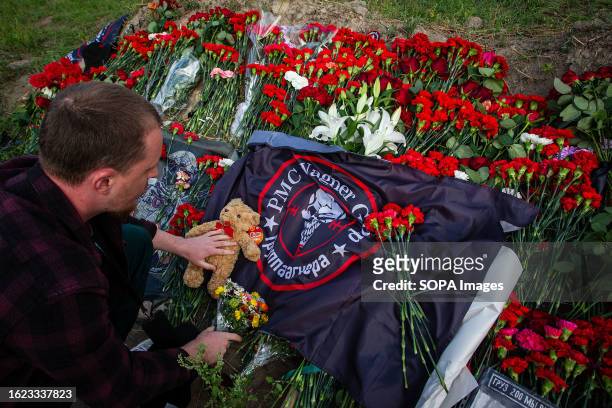Man lays flowers in memory of Yevgeny Prigozhin at a spontaneous memorial near the PMC Wagner Center in St. Petersburg. On Wednesday, August 23, the...