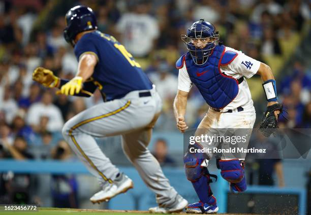 Austin Barnes of the Los Angeles Dodgers runs down Tyrone Taylor of the Milwaukee Brewers at Dodger Stadium on August 17, 2023 in Los Angeles,...