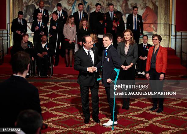 France's President Francois Hollande congratulates French fencer Ludovic Lemoine, silver medalist at the 2012 London Paralympic Games, after awarding...