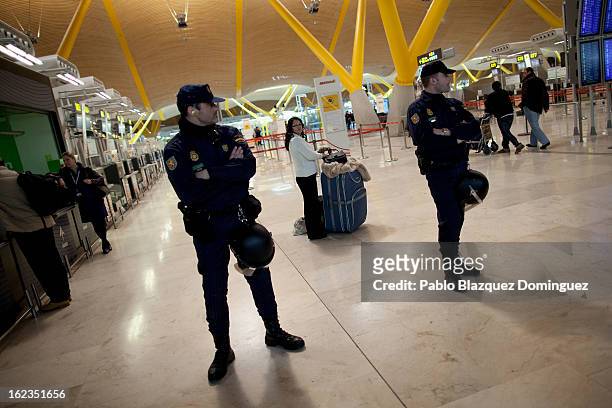 Passenger stands behind a police cordon during a protest of Spanish Airline Iberia staff against job cuts at Barajas Airport on February 22, 2013 in...