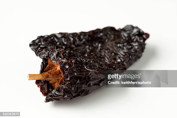 an ancho chili on a white background - ancho stockfoto's en -beelden