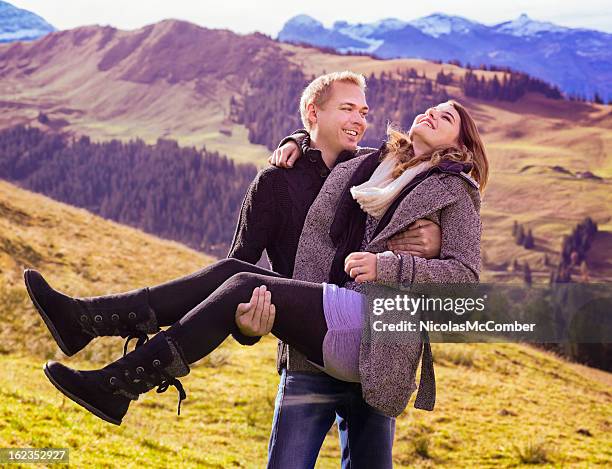 glücklicher mann führt seine freundin in schweizer alpen - nicolas berggruen stock-fotos und bilder