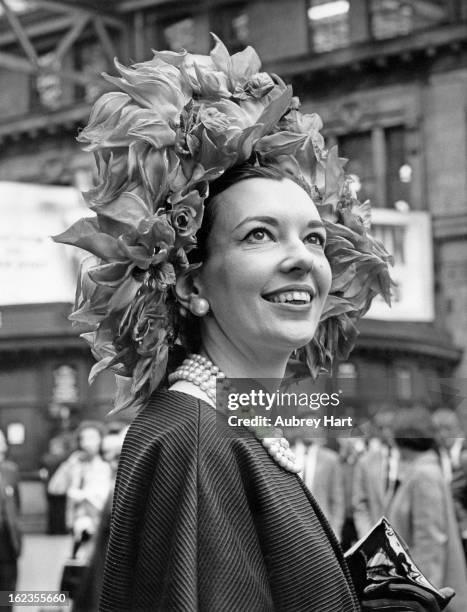 Journalist and novelist Una-Mary Parker, the wife of Archie Parker of Knightsbridge, wears a black silk coat and a hat decorated with red silk rose...