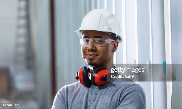 multiracial man at construction site in white hardhat - three quarter front view stock pictures, royalty-free photos & images