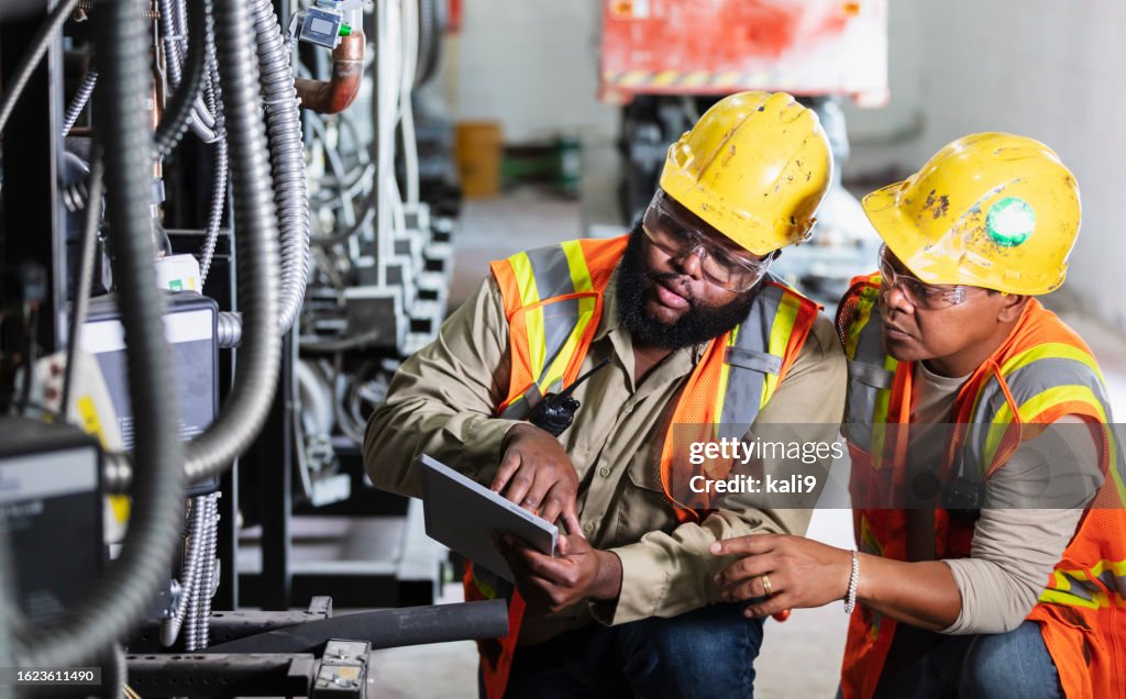 Two workers inspecting industrial refrigeration equipment