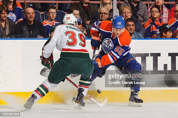 Ben Eager of the Edmonton Oilers skates with the puck against Nate Prosser of the Minnesota Wild during an NHL game at Rexall Place on February 21,...