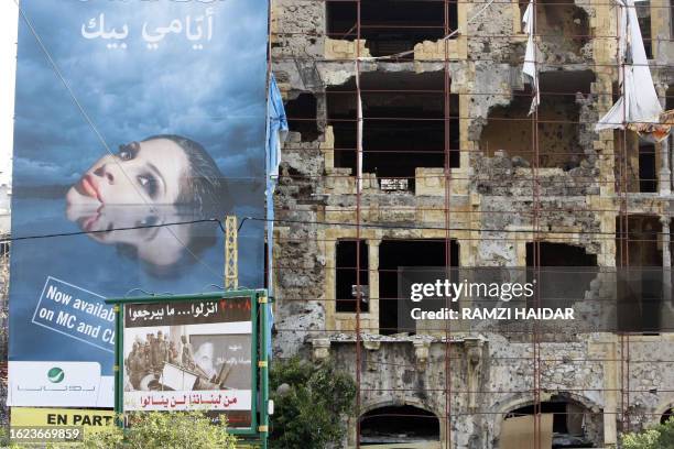 Poster of Arab pop singer Elissa hangs February 11, 2008 next to an anti-Syrian advertisement campaign, on a building in Beirut destroyed during the...