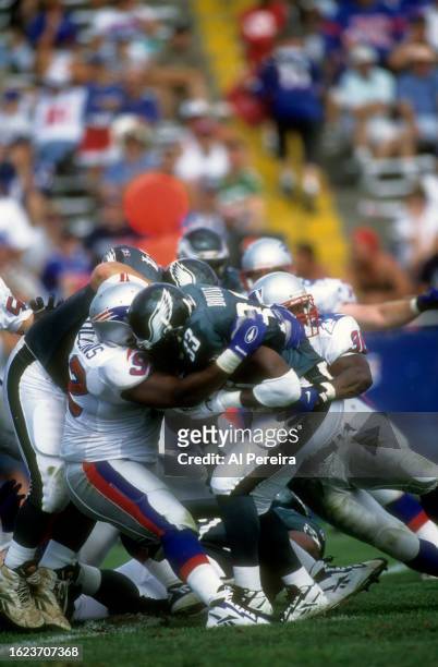 Strong Safety Lawyer Milloy and Defensive End Ferric Collons of the New England Patriots make a stop in the game between the Philadelphia Eagles vs...