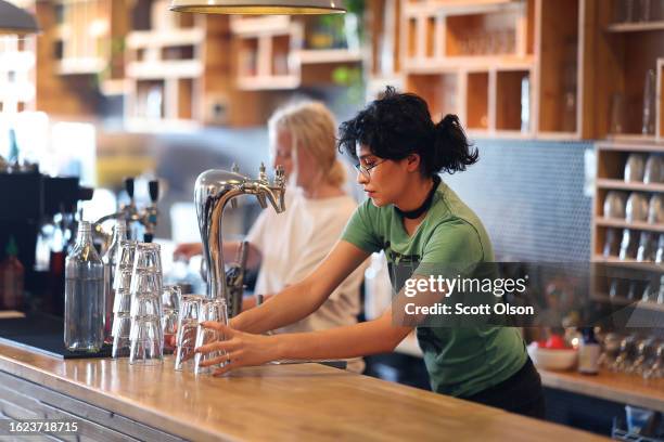 Eden Austin waits on customers at the Same Day Cafe in the Logan Square neighborhood on August 18, 2023 in Chicago, Illinois. The city of Chicago is...