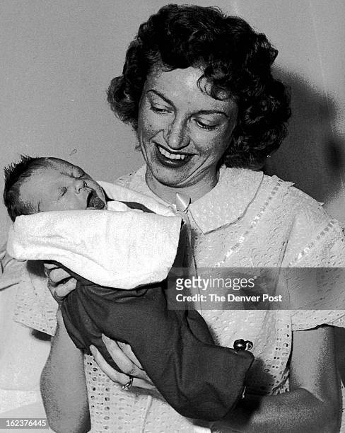 First Stocking Filled at Hospital; David Allen Peterson, the first Christmas baby born at Presbyterian hospital, is held by his mother, Mrs. Shirley...