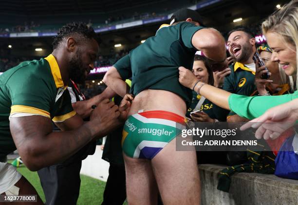 South Africa's flanker Siyamthanda Kolisi signs the underwear of a supporter after the pre-World Cup Rugby Union match between New Zealand and South...