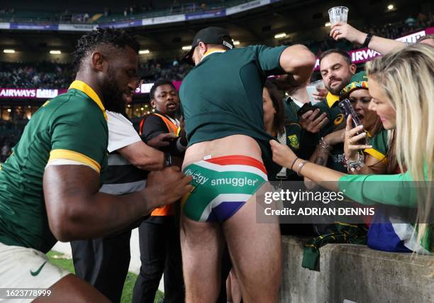 South Africa's flanker Siyamthanda Kolisi signs the underwear of a supporter after the pre-World Cup Rugby Union match between New Zealand and South...