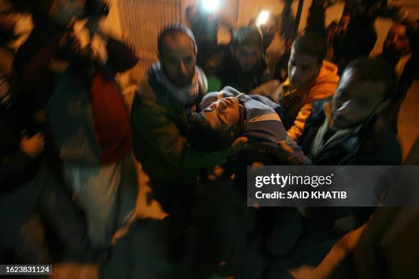 Palestinians carry a wounded man at al Najar a hospital in the southern Gaza Strip town of Rafah on March 19, 2010 after Israeli aircraft hit a...