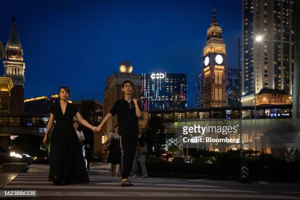Couple hold hands while walking on the Cotai strip in Macau, China, on Thursday, Aug. 24, 2023. Macau's economy continued to recover, driven by the...