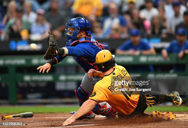 Bryan Reynolds of the Pittsburgh Pirates slides in to score in front of Yan Gomes of the Chicago Cubs during the first inning at PNC Park on August...