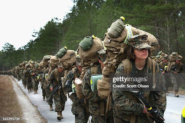Marines, both male and female, participate in a 10 kilometer training march carrying 55 pound packs during Marine Combat Training on February 22,...