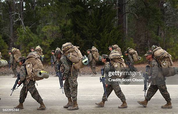 Marines, both male and female, participate in a 10 kilometer training march carrying 55 pound packs during Marine Combat Training on February 22,...