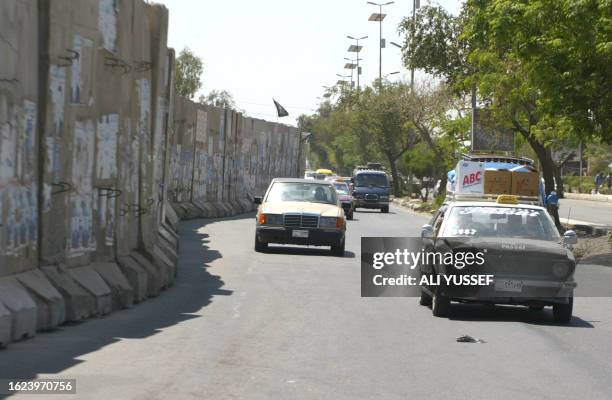 Vehicles drive past a concrete T-wall in central Baghdad on April 21 2009, which was erected at the height of the sectarian violence by US and Iraqi...